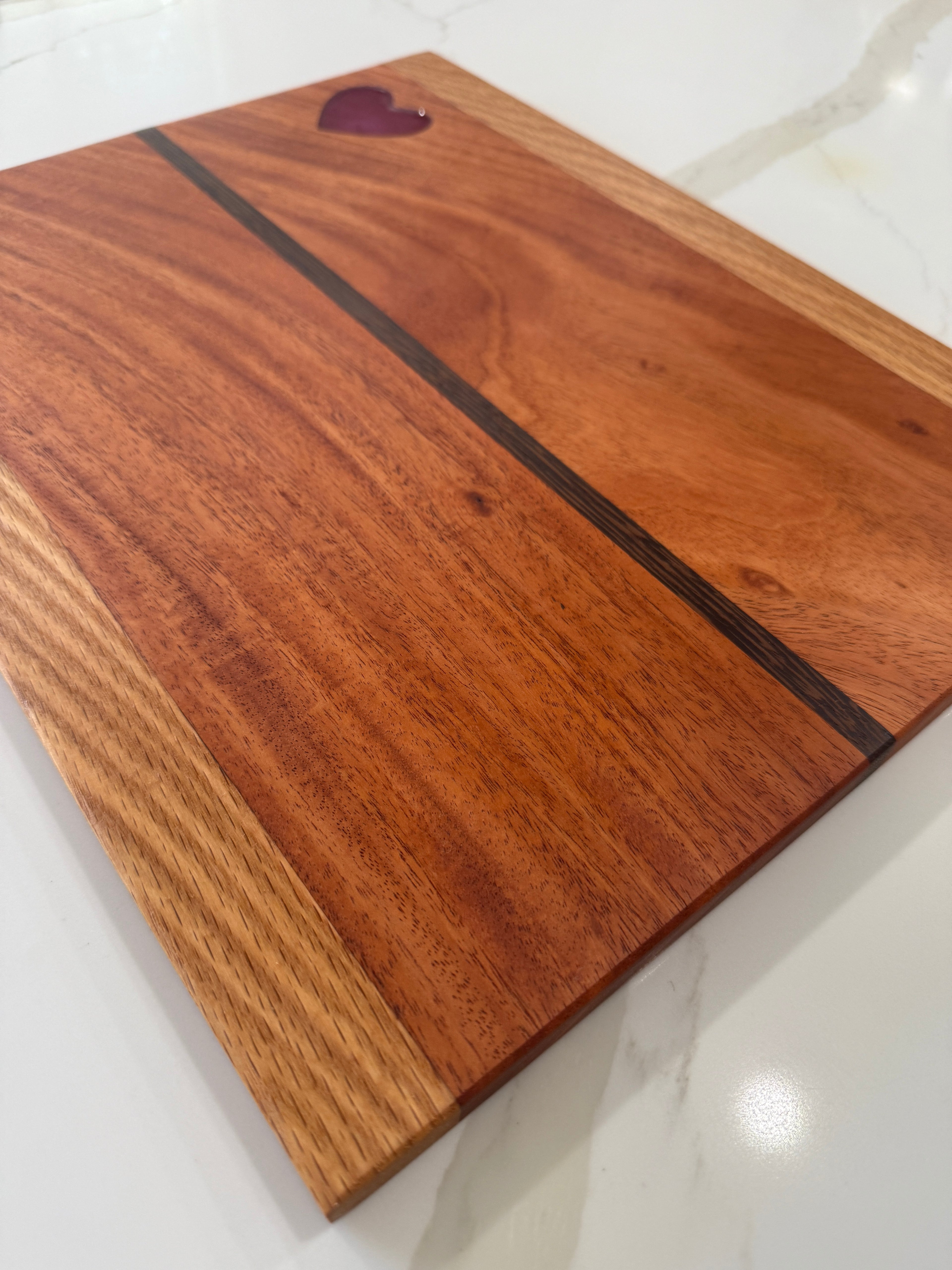 Red Heart epoxy Inlay with Padauk Wood Cutting Board, highlighted with a Strip of Wenge Wood.