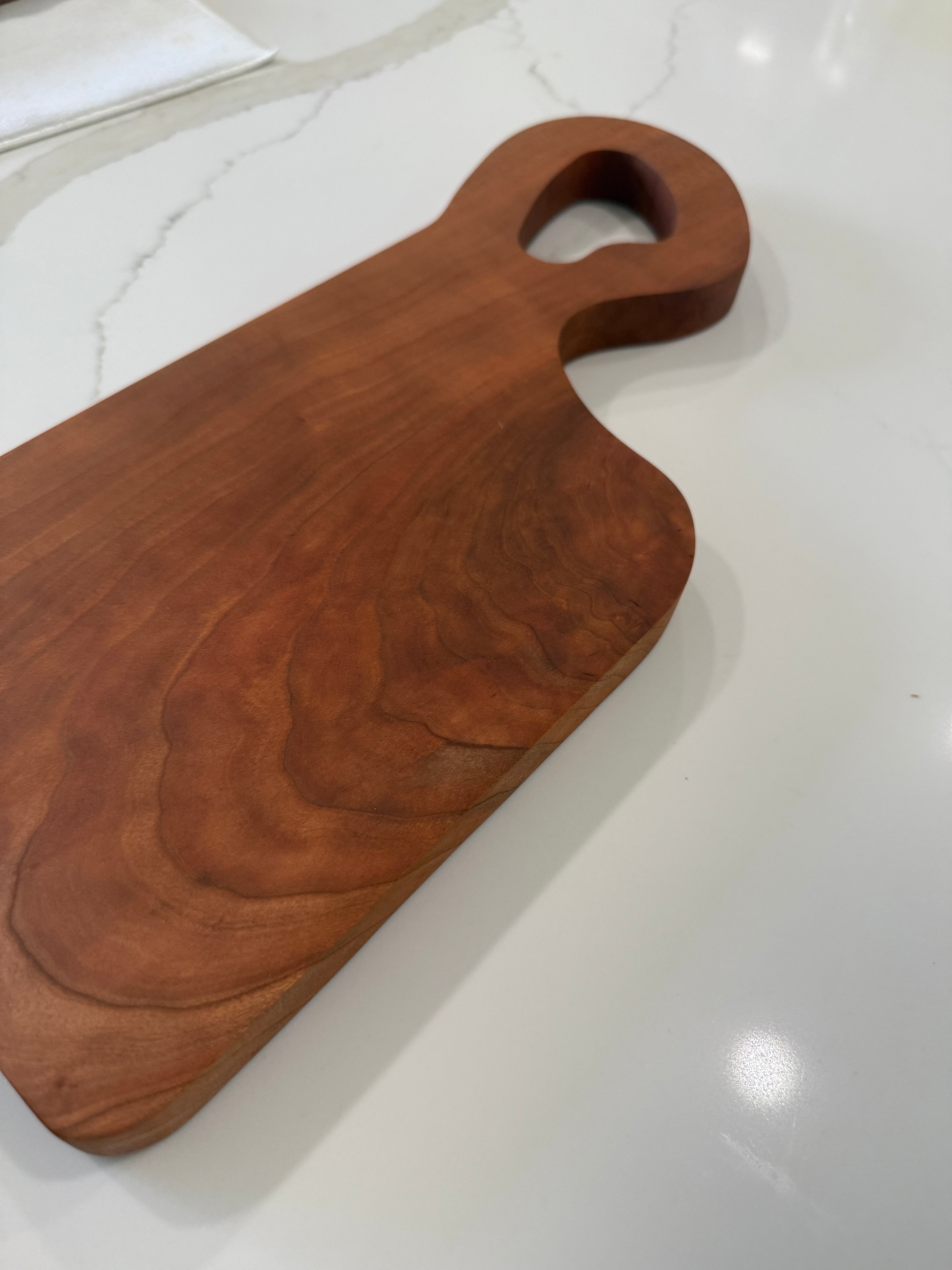 Unique offset handle with Premium Cherry Wood Cutting Board.