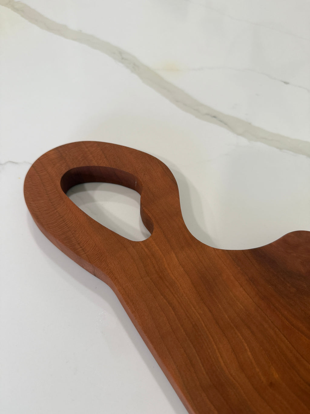 Unique offset handle with Premium Cherry Wood Cutting Board.