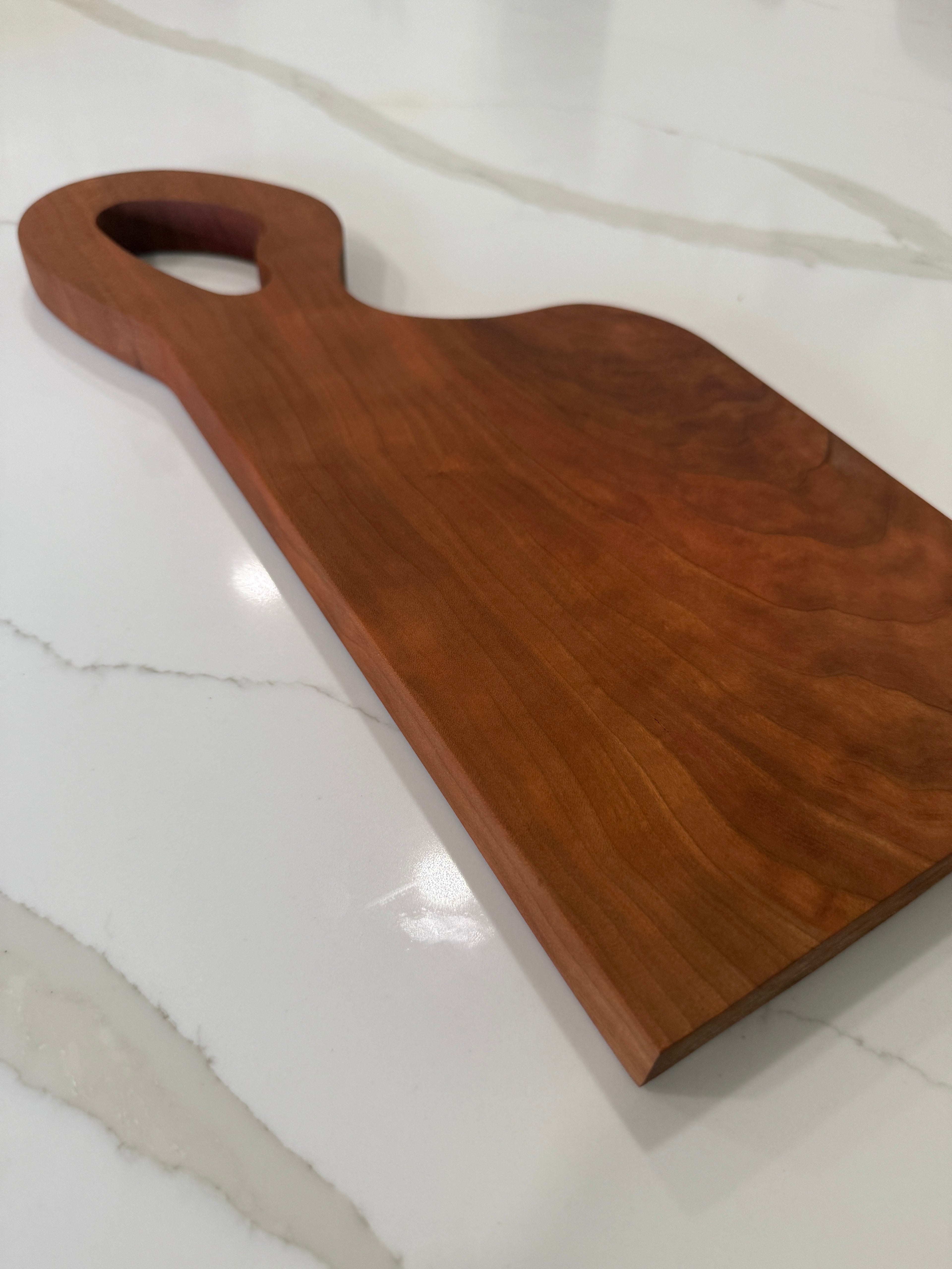 Unique offset handle with Premium Cherry Wood Cutting Board.